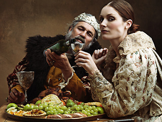 Image showing King, queen and portrait with wine at table for fine dinning in royal banquet, vintage and majestic with crown. Monarch, husband and pour alcohol for buffet or feast for formal celebration and drink.