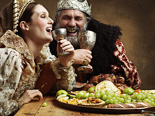 Image showing King, queen and buffet with wine at table for fine dinning in royal banquet, vintage and majestic with crown. Monarch, husband and people together with alcohol and feast for formal celebration