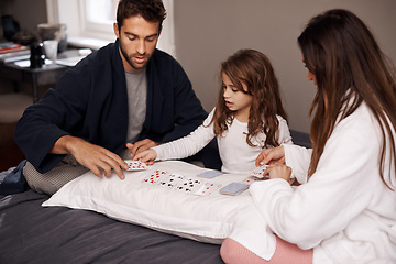 Image showing Parents, girl and fun with playing cards for game for bonding, learning and relax with strategy in bedroom. Father, mother and daughter with deal, maths and teaching with connection in family house
