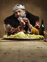 Image showing Portrait, king and feast in table with wine as royalty on dining hall for tradition, culture and meal in palace. Confident, monarch and leader with eating buffet or supper as lord with crown