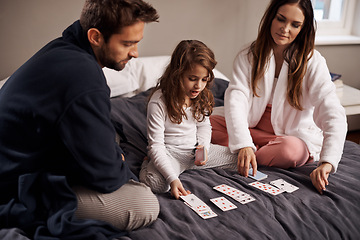 Image showing Mom, dad and girl with playing cards to relax in home with bonding, learning or fun with strategy in bedroom. Father, mother and daughter with games, maths or teaching with connection in family house