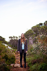 Image showing Woman, hiking and smile in nature for portrait on path with fitness, outdoor or adventure on holiday. Girl, person and happy for trekking in bush, hill and rocks for journey on vacation in Cape Town