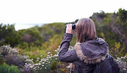 Image showing Woman, binoculars and hiking for mountain view on trekking path for exploring, adventure or journey. Female person, backpacking and traveling workout for wilderness fitness, vacation or environment