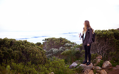 Image showing Woman, hiking and nature with bottle, water and space for mockup with fitness, vision or memory on adventure. Girl, person and hydration in bush, mountains and path for journey by ocean in Cape Town