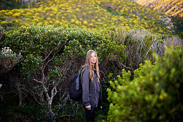 Image showing Landscape, portrait and woman hiking with smile, vacation and adventure with backpack for journey. Adult, girl and female person in holiday for winter in nature of Cape Town for plants in bush