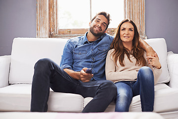 Image showing Couple, watching tv on sofa and relax together in living room with streaming service, trust and hug for bonding. Man, woman with Netflix and chill on the weekend, marriage and remote for television