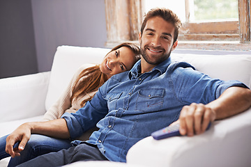 Image showing Happy couple, watching tv on sofa and relax together in living room with streaming service, trust and hug for bonding. Man, woman with Netflix and chill in portrait, partner and remote for television