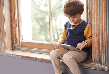 Image showing Home, tablet and serious child on internet, app or game on website for learning by windowsill. Technology, kid and boy in house for education, relax and watch cartoon online on digital electronics