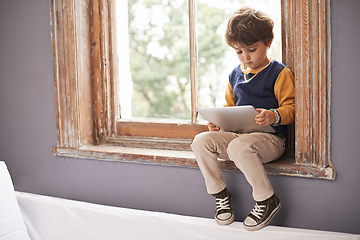 Image showing Home, tablet and serious kid on internet, app or game on website for learning by windowsill. Technology, child and boy in house for education, relax and watch cartoon online on digital electronics