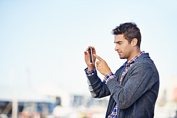 Image showing Man, phone and photography at harbor, outdoor and space for mockup with creativity on urban sidewalk. Person, photographer and smartphone for vacation, profile picture or memory on road in Cape Town