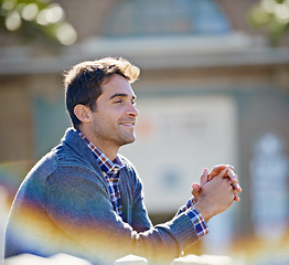 Image showing Man, smile and outside for thinking memory and trip for travel or relax in outdoor for fresh air. Young person, sitting and cheerful and looking for view and break for good mood and joy on vacation