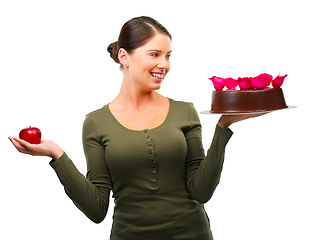 Image showing Woman, apple and cake for choice in studio with smile, thinking and ideas for diet by white background. Girl, person and model with bakery snack, fruit and decision for health, wellness or nutrition