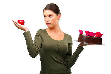 Image showing Woman, apple and cake for choice in studio with options, thinking and ideas for diet by white background. Girl, person and model with dessert, fruit and decision for health, wellness and nutrition