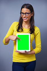 Image showing Woman, tablet and green screen for studio portrait with pointing, presentation or show ux by grey background. Student, person and digital touchscreen with chromakey for mockup space, app or promotion