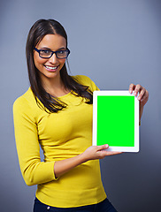 Image showing Woman, tablet and green screen with space for studio portrait with presentation, show or ux by blue background. Student, person and digital touchscreen with chromakey for mockup, app and promotion