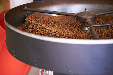 Image showing Coffee beans, machine and factory for roast, product and cooling tray for flavor, export or quality assurance. Plant, metal container and caffeine manufacturing with organic stock for sustainability