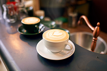 Image showing Coffee on table, cup and latte with art for creativity, cappuccino or caffeine drink with pattern. Warm beverage on counter, foam and milk with heart or leaf design, hospitality and service at cafe
