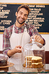 Image showing Man, waiter and cake on counter in cafe for display, service or catering with smile in portrait. Person, barista or business owner in coffee shop, bakery or diner with pride, show and point in Italy