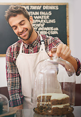 Image showing Man, waiter and cake on counter in coffee shop for display, service and catering with smile in morning. Person, barista or business owner in cafe, bakery or diner with pride, ideas and snack in Italy