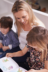 Image showing Reading, woman and children on sofa with book for bonding, teaching and learning together in home. Mother, son and daughter relax on couch with storytelling, smile and happy family in living room