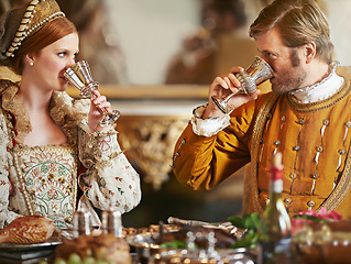 Image showing Couple, noble and wine with luxury, feast and renaissance dining table at royal home. King, queen and food with wealth, rich meal and palace or manor for romance with historical chalice and drink