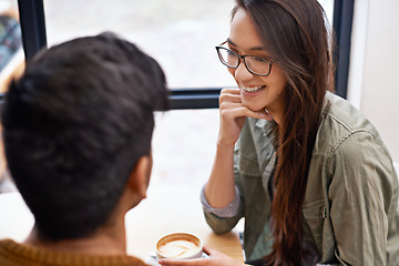 Image showing Couple, date and coffee shop with happy conversation and talking together with hot drink in a cafe. Woman, smile and joy from discussion and chat in a restaurant with tea or cappuccino at a table