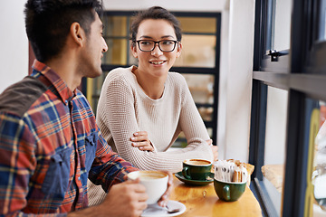 Image showing Happy couple, window and relax with coffee at cafe for chatting, talking or social bonding. Young man and woman with smile for conversation, beverage or morning drink at indoor restaurant together