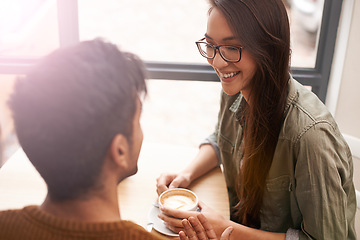 Image showing Couple, date and coffee shop with conversation, smile and talking together with hot drink in a cafe. Woman, social and happy from discussion and chat in a restaurant with tea or cappuccino at table