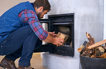 Image showing Fireplace, hearth and man with wood for fire for heat, warmth and light in winter in home. Flame, burning and person with firewood or logs for comfortable, cozy and relaxing atmosphere in living room