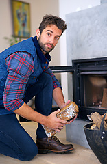 Image showing Fireplace, wood and portrait of man in home for heat, warmth and light in winter. Flame, burning hearth and person with firewood, logs and fire for comfortable, cozy and relaxing house in living room