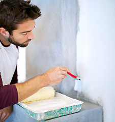 Image showing Painting, wall and man in home for renovation, remodeling and maintenance with white paint. Interior design, decoration and person with paintbrush, roller and equipment for DIY project in house