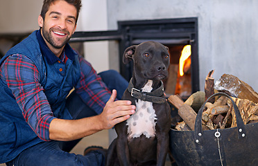 Image showing Fireplace, dog and portrait of man with fire in home for heat, warmth and light in winter. Flame, wood and person with pet bonding with firewood for comfort, cozy and relaxing house in living room