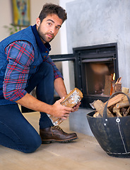 Image showing Fire, log and portrait of man at fireplace for heat, warmth and light in winter in home. Season, burning and person with firewood, flame wood for comfortable, cozy and relaxing house in living room
