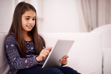 Image showing Relax, home or girl with tablet for elearning, playing games or streaming videos on a movie website. Education, online or female child with technology to download on app or reading ebook on couch