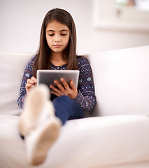 Image showing Relax, sofa or girl with tablet for elearning, playing games or streaming videos on a movie website. Education, online or child in home with technology to download on app or reading ebook on couch