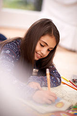 Image showing Girl, coloring book and smile on floor for sketch in home for learning, development or drawing in lounge. Kid, art and education for studying, creativity or relax on carpet at family house in Madrid