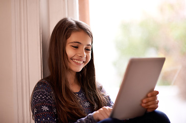 Image showing Girl, child and tablet, happy with technology and relax with ebook for reading and social media at home. Website, cartoon or storytelling app with internet, browse and digital platform for gaming