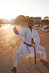 Image showing Serious man, karate and fitness with self defense in city for kata, fighting technique or style. Young male person or muay thai fighter in training, martial arts or stance on street or road in town