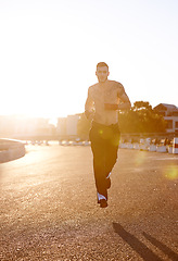 Image showing Man, running and martial arts in street for exercise, training and cardio for health, stamina and tattoo in sunshine. Fighter, outdoor and road for workout in morning, sunrise and mma for wellness