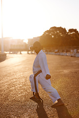 Image showing Man, martial arts and karate in street for portrait with fist, balance or warrior for battle in city. Person, contact sports and fight with power, conflict and self defence in road, outdoor or sunset