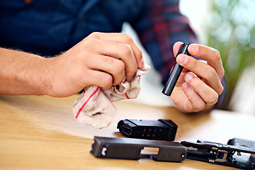 Image showing Hands, cleaning and man with gun at table for safety, self defense and handgun assembly. Process, equipment and person with firearm maintenance with cloth, magazine and wiping dust, dirt and oil