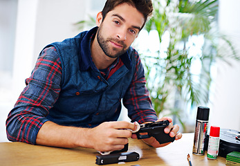 Image showing Portrait, cleaning and man with gun at table for safety, self defense and confident handgun assembly. Process, equipment and person with firearm maintenance, cloth and wiping dust, dirt and tools