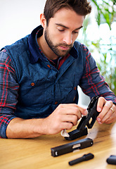 Image showing Process, cleaning and man with gun at table for safety, self defense and confident handgun assembly. Caution, equipment and person with firearm maintenance, cloth and wiping dust, dirt and tools