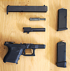 Image showing Gun, tabletop and high angle for weapon, dangerous and pistol for self defence or security and danger. Handgun, piston and risk with parts for assemble, shoot and bullet for police equipment indoor