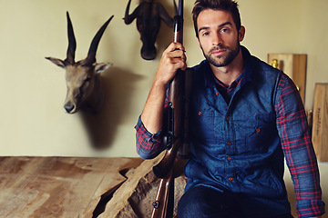 Image showing Portrait, hunter and man with trophies, gun and confidence with business and resort with achievement. Face, person and game hunter with weapon and animal heads with firearm and equipment with pride