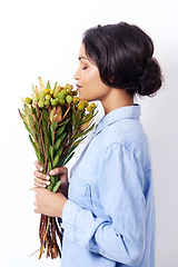 Image showing Women, bouquet and flowers in studio for smell and botany for leaves with stem for bloom. Mexican lady and young person holding plant for spring, blossom and bunch for gift and green with eyes closed