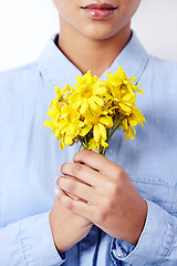 Image showing Hands, woman and daisy bouquet in studio with closeup, fashion or sustainability by white background. Person, model and girl with yellow flowers, plants and organic shirt with ecology for environment