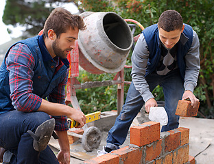 Image showing Men, tools and bricks in outdoor with cement for construction, building or masonry for job or skill. Young people, bricklayer or artisan and talking with equipment for builder or worker for wall