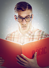 Image showing Surprise, glowing pages and man with a book, reading and expression on grey studio background. Person, magic and reader with novel or literature with fantasy and shocked for story or wow with glasses