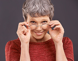 Image showing Portrait, senior woman and glasses with smile, retirement and confident pensioner on a grey studio background. Face, old person and elderly lady with eyewear for clear vision and optometry with joy
